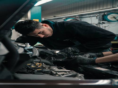 Mécanicien de Garage Factory 31 au travail sur un moteur